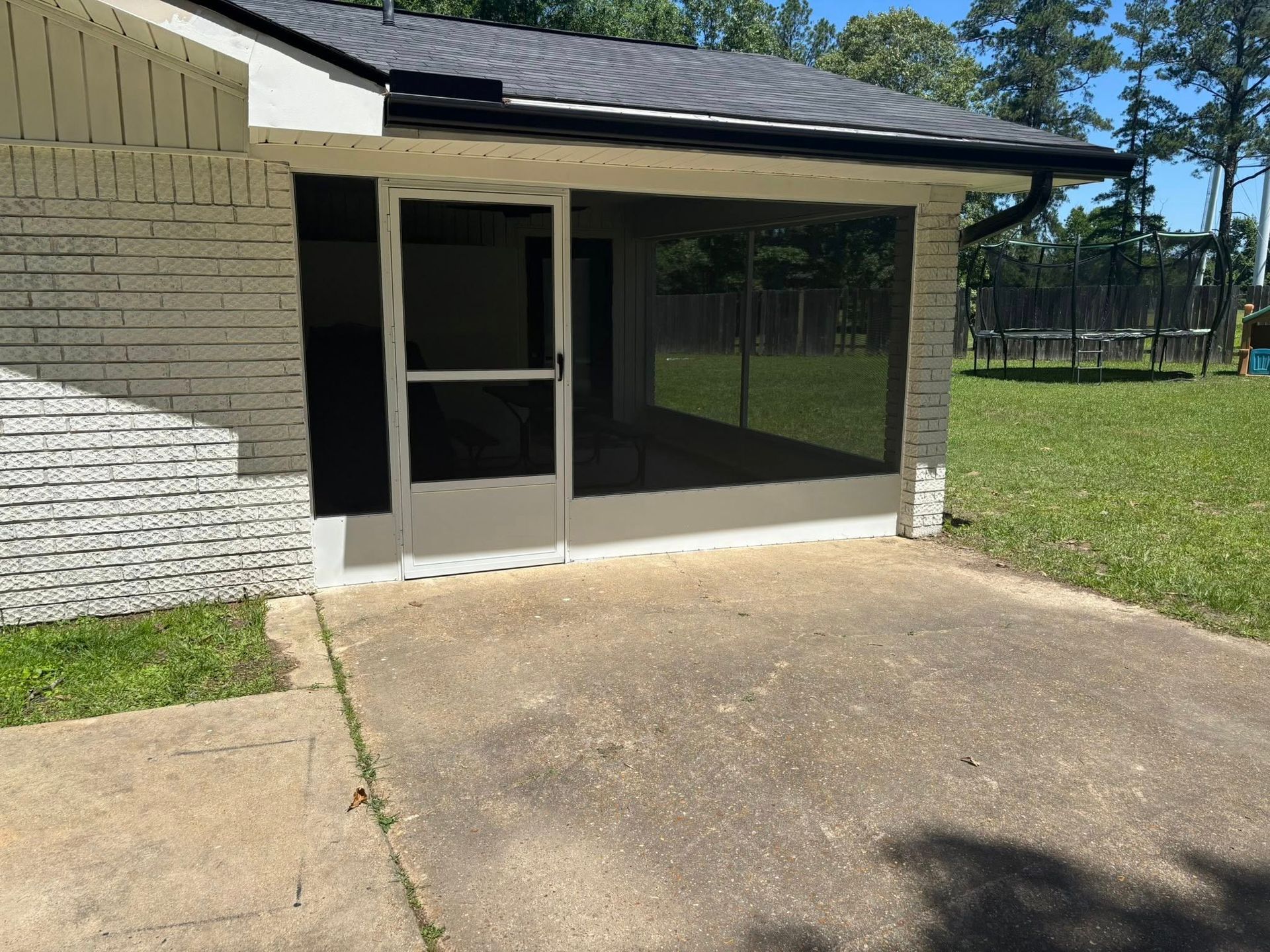 A screened in porch on the side of a house
