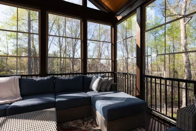 Cozy seating area inside a bright screened enclosure.