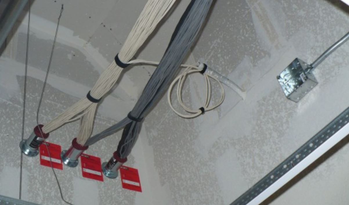 A bunch of wires are hanging from the ceiling