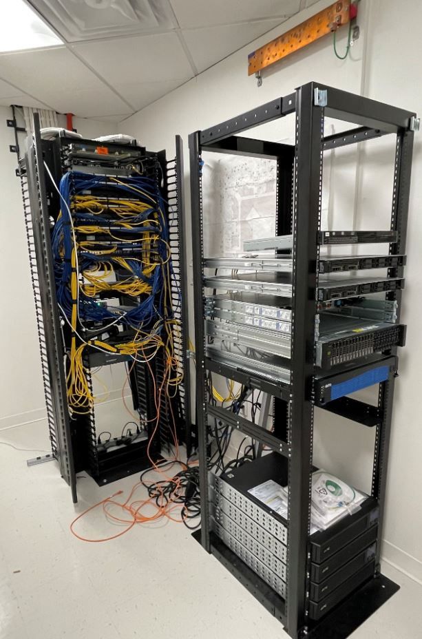 Two server racks are sitting next to each other in a room.