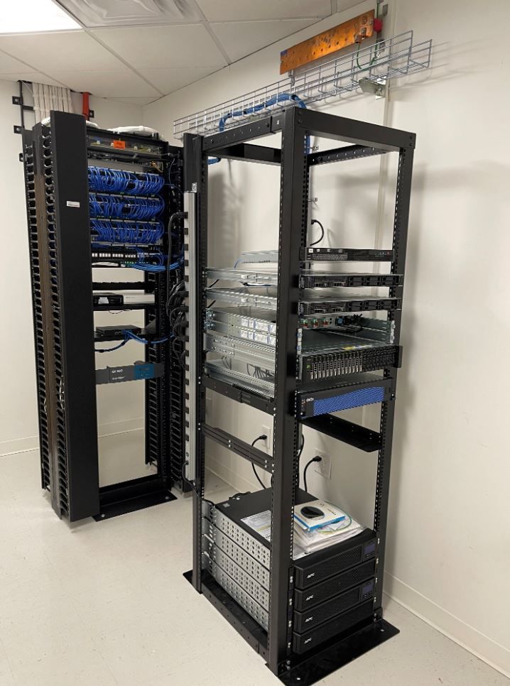 Two server racks are sitting next to each other in a room.