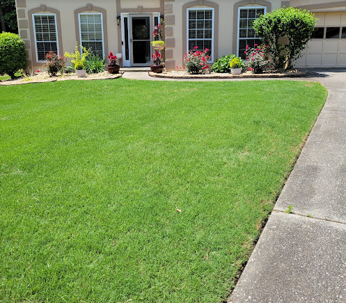 A lush green lawn is in front of a house.