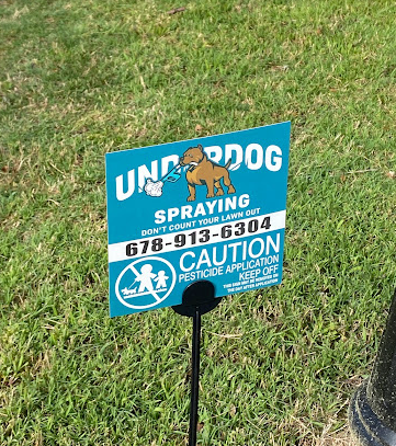 A sign that says underdog spraying on it