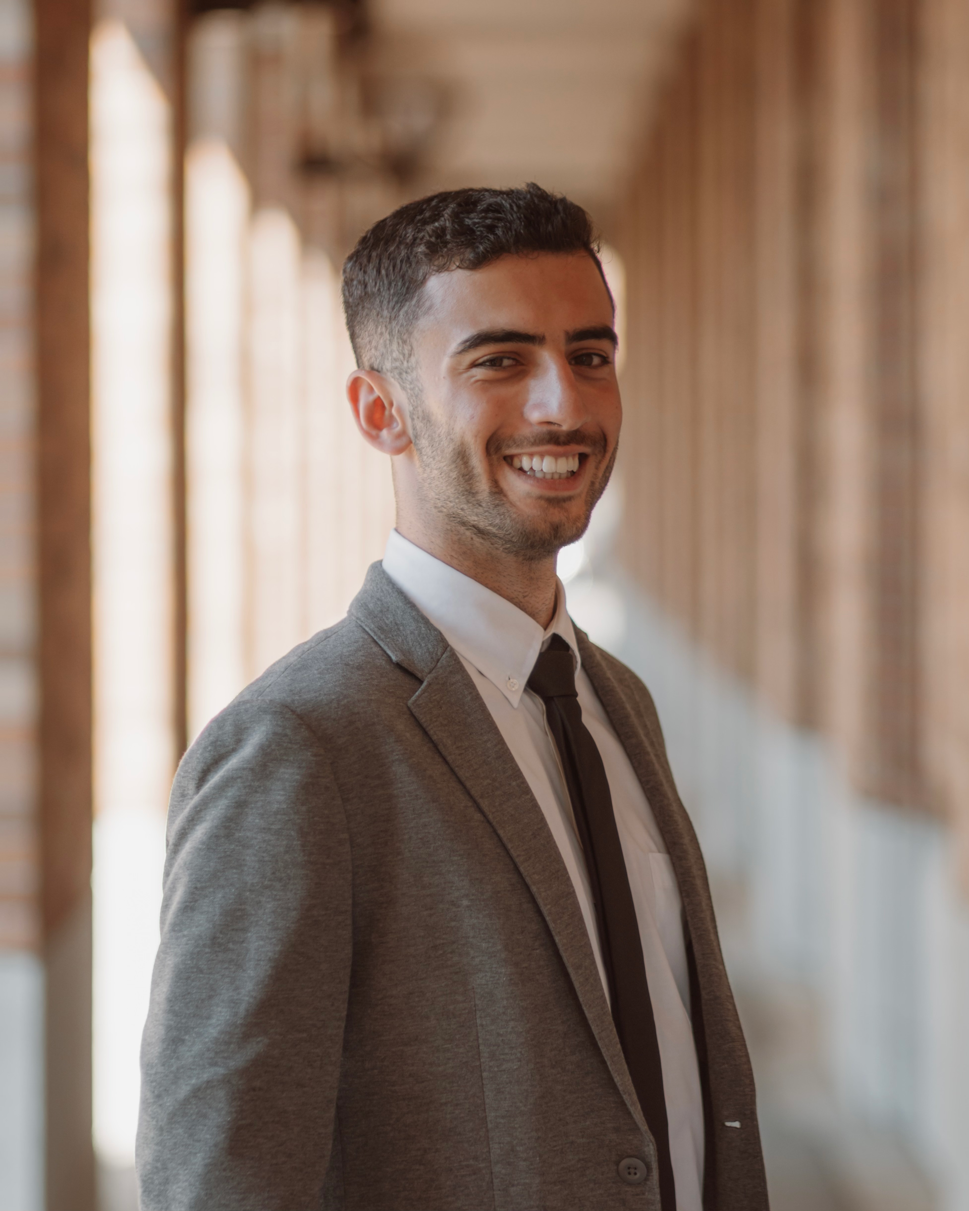 A man in a suit and tie is smiling for the camera.