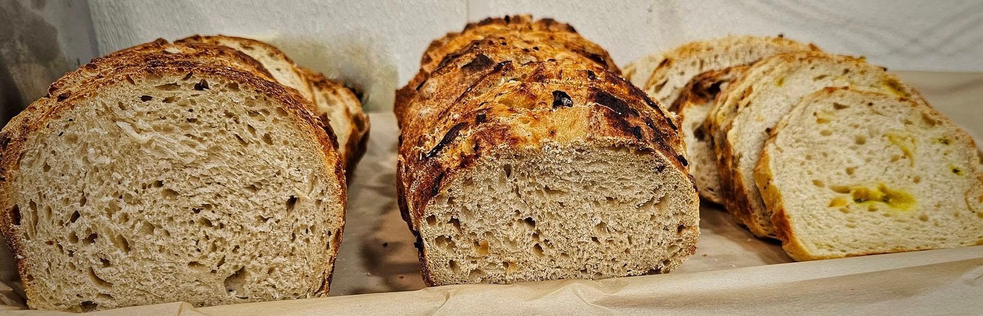 Three loaves of bread are sitting on a table.