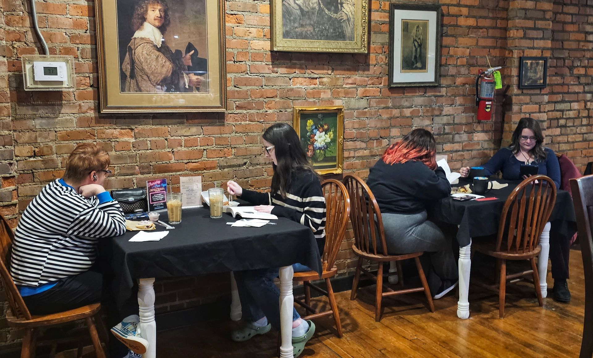 A group of people are standing in a room talking to each other.