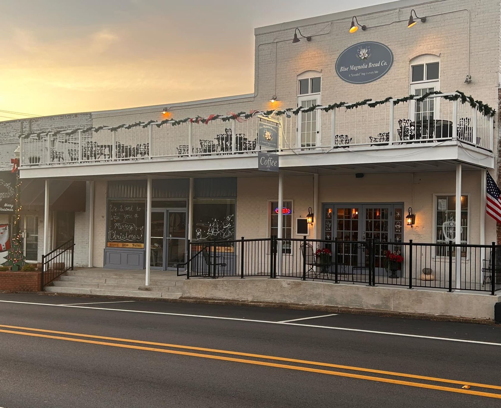 A large white building with a balcony and an american flag