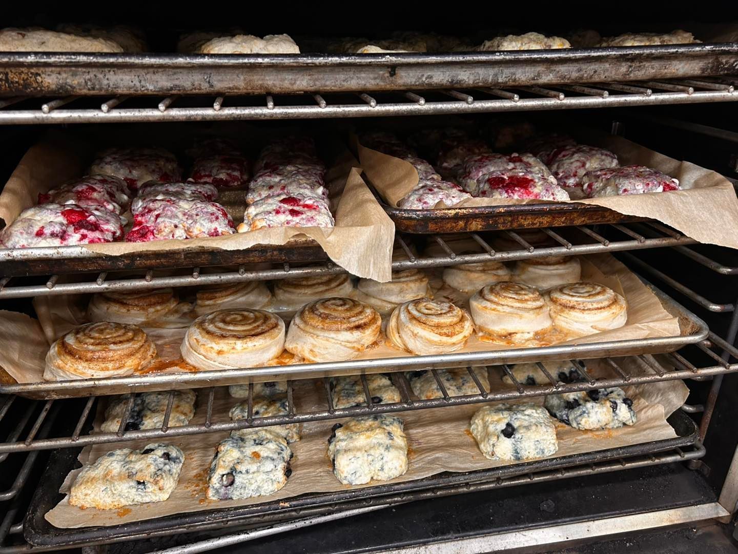A bunch of pastries are sitting on a rack in an oven