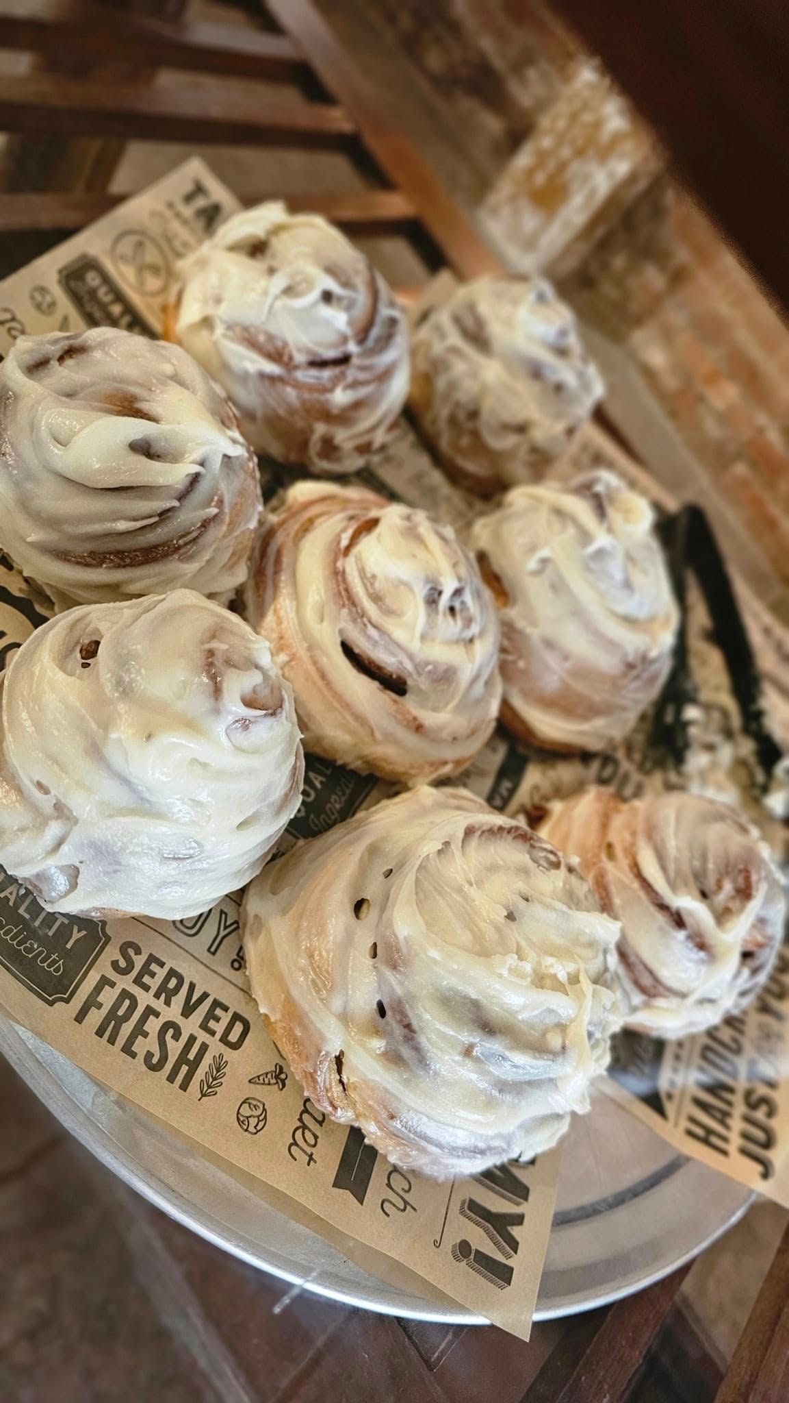 A close up of a plate of cinnamon rolls on a table.