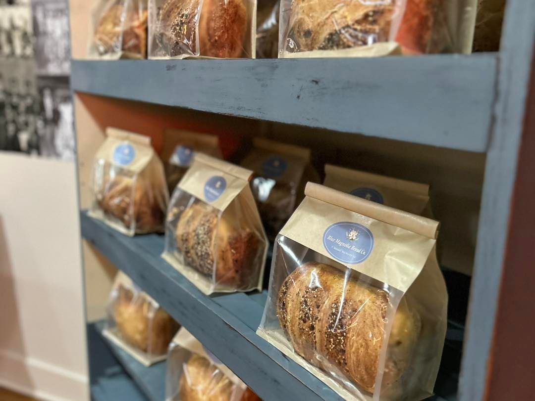 A shelf filled with bags of bread in a bakery