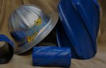 A hard hat is sitting next to some blue pipes