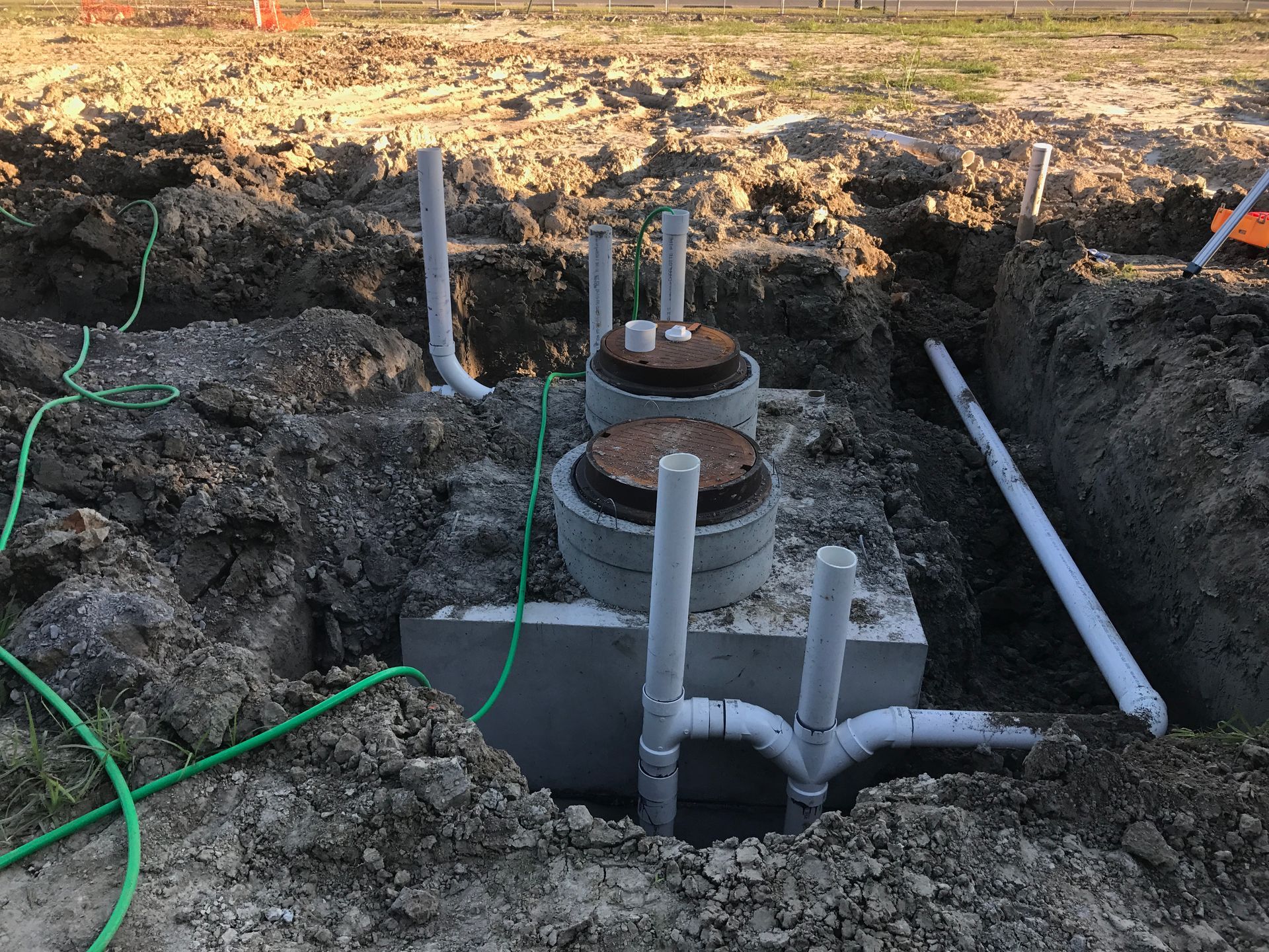 A septic tank is being installed in a dirt field.