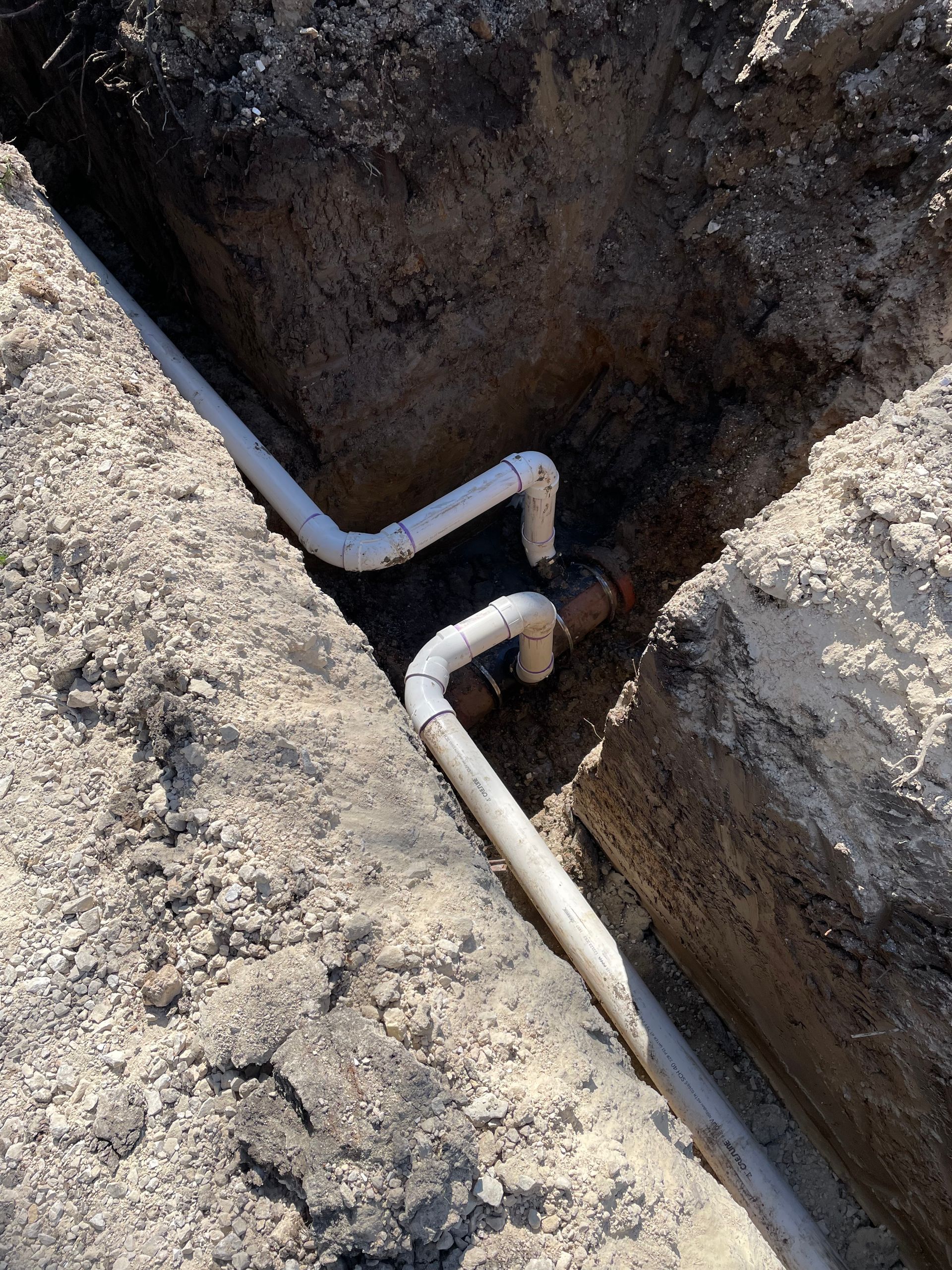 A couple of pipes are connected to each other in the dirt.