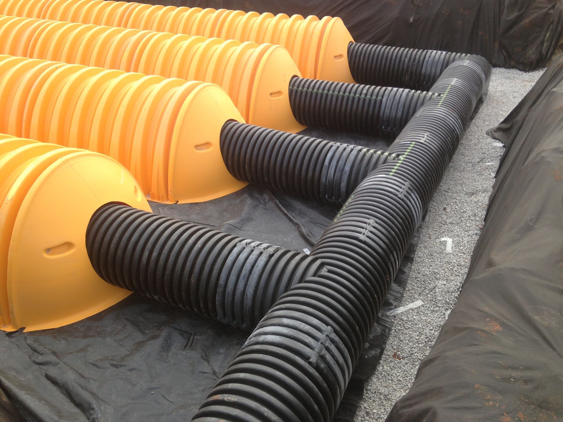 A bunch of yellow and black pipes are laying on the ground