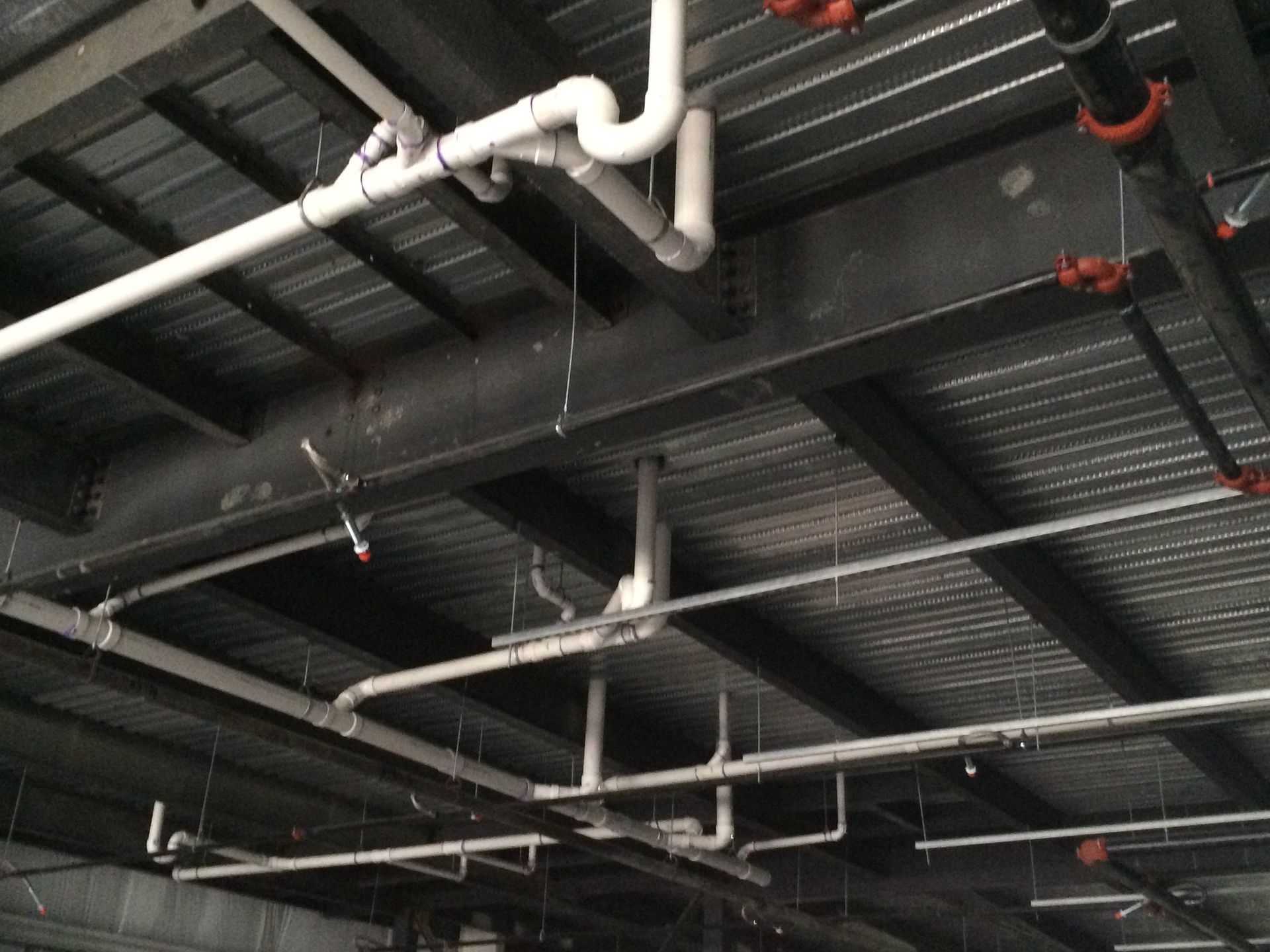 A ceiling with a lot of pipes hanging from it