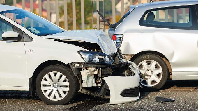 A white car and a silver car are involved in a car accident.