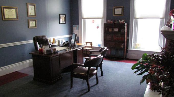 A room with a desk and chairs in it