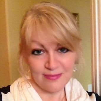 A close up of a woman 's face wearing a scarf and earrings.