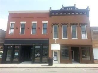 A large brick building with a lot of windows on a city street.