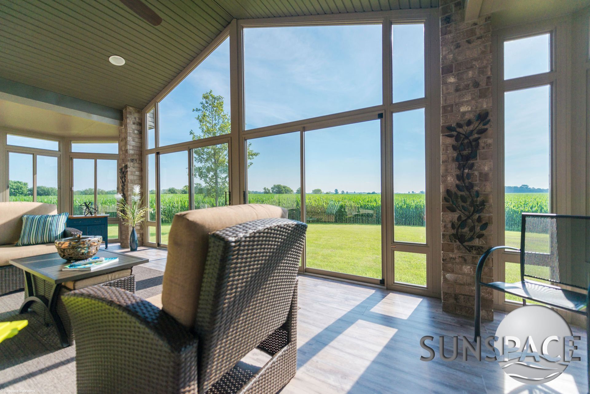 A living room with a lot of windows and a view of a field.