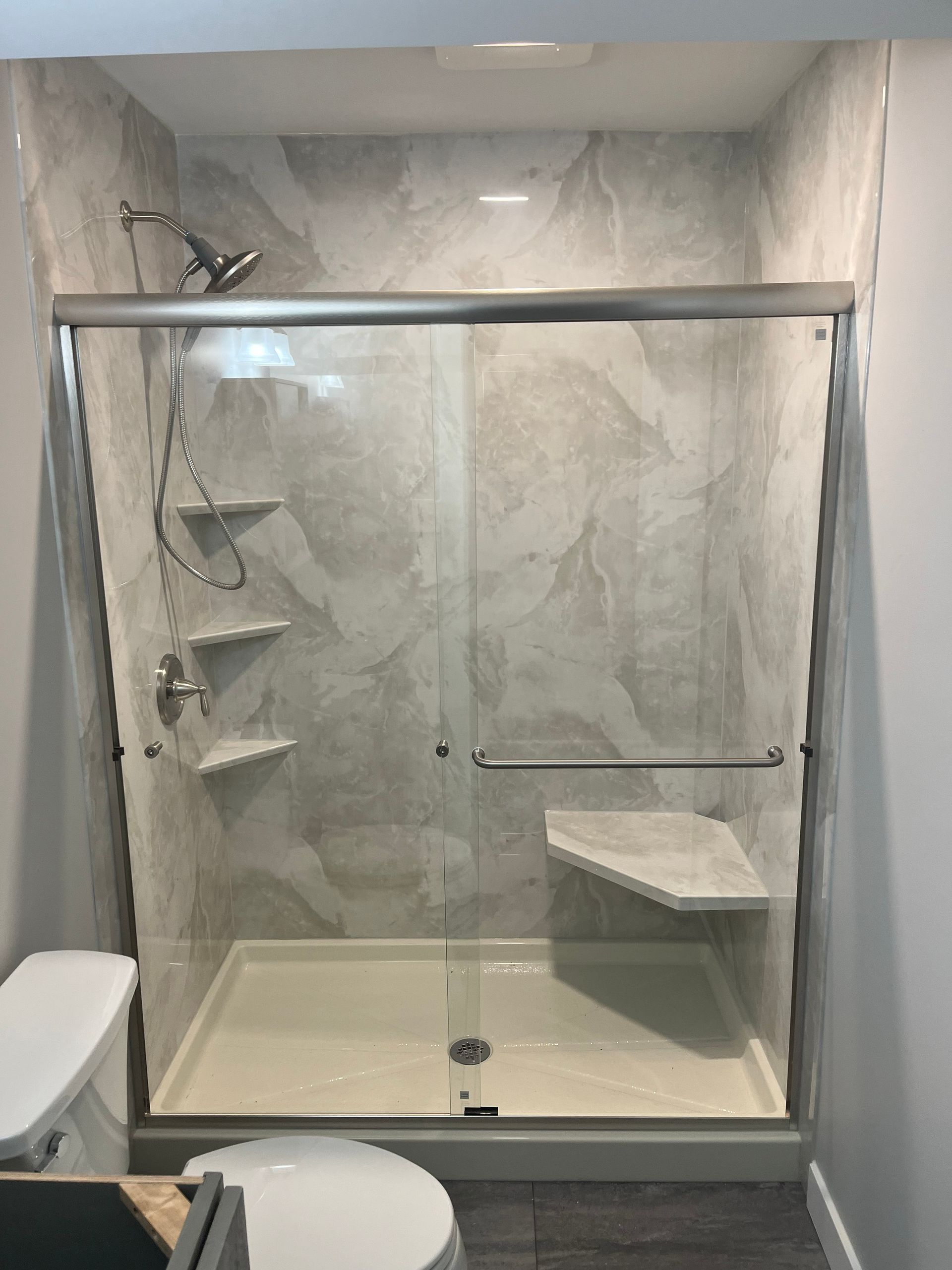 A bathroom with a sliding glass shower door and a toilet.