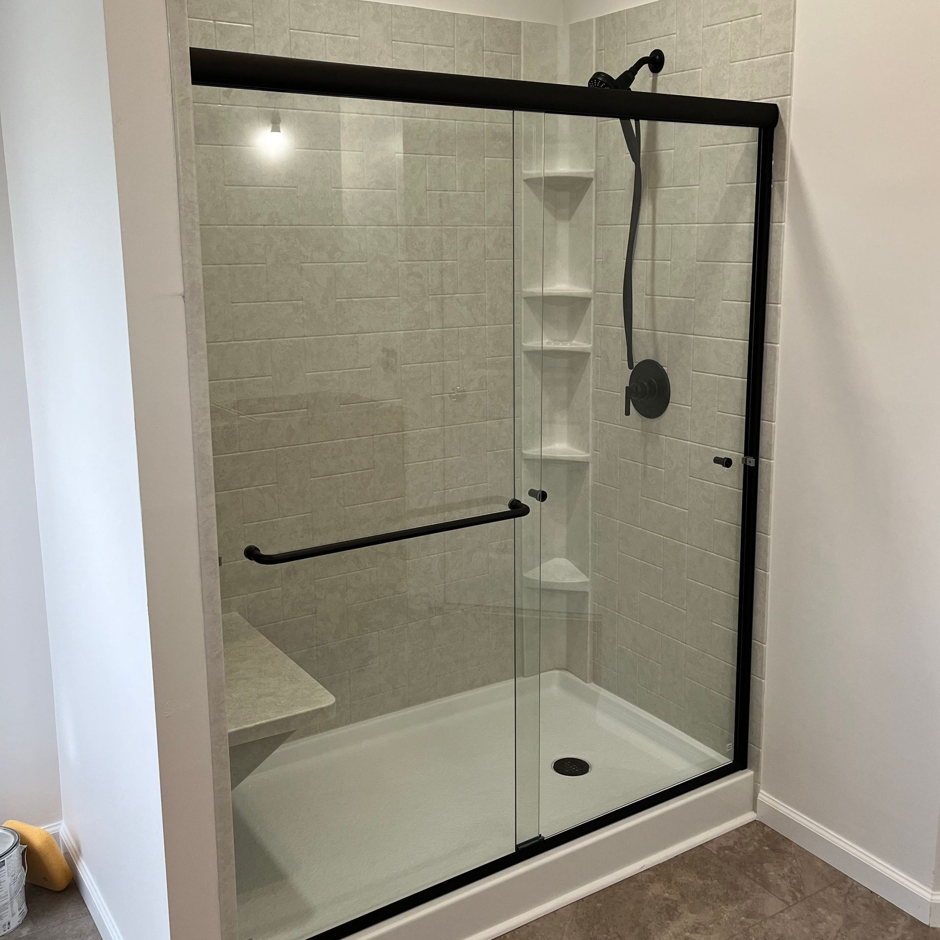 A bathroom with a sliding glass shower door and a shower head.