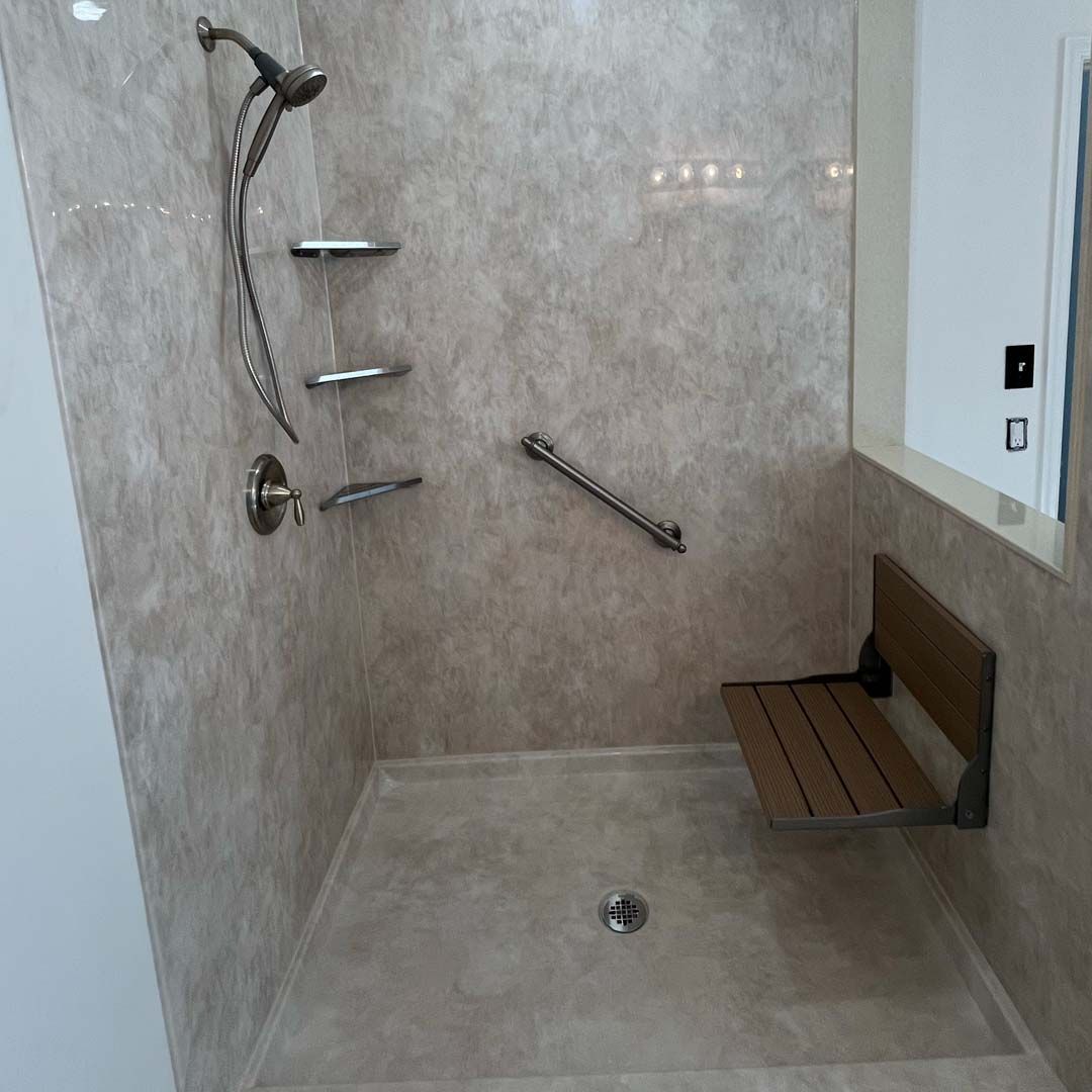 A walk in shower with a wooden seat and a hand rail.