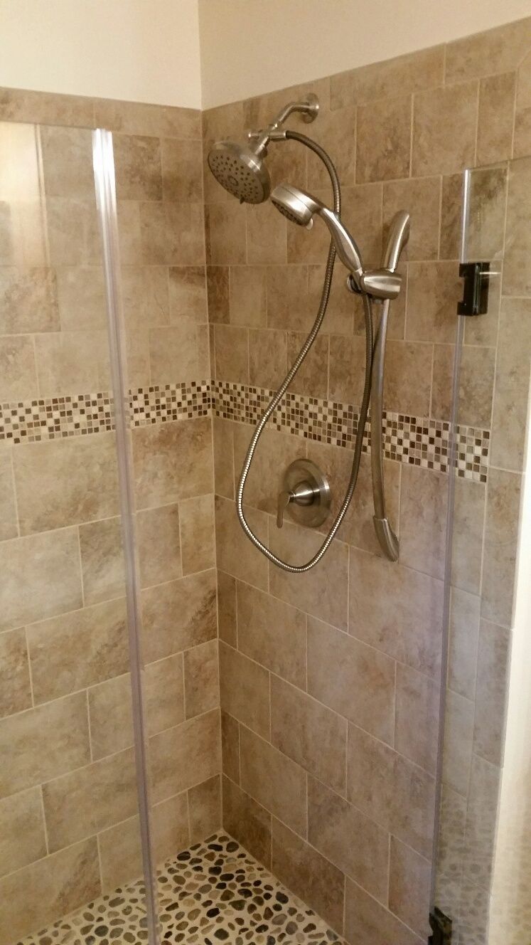 A shower with a glass door and a shower head.