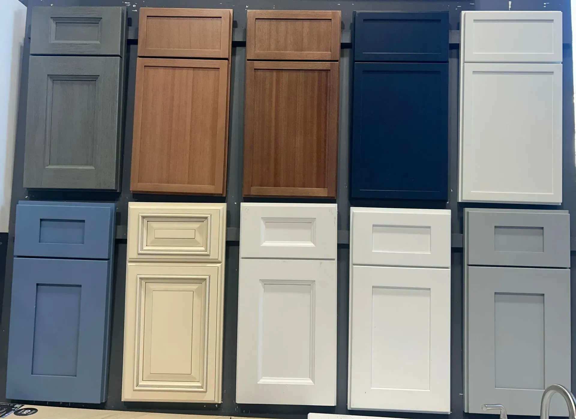 A variety of cabinet doors are displayed on a wall.