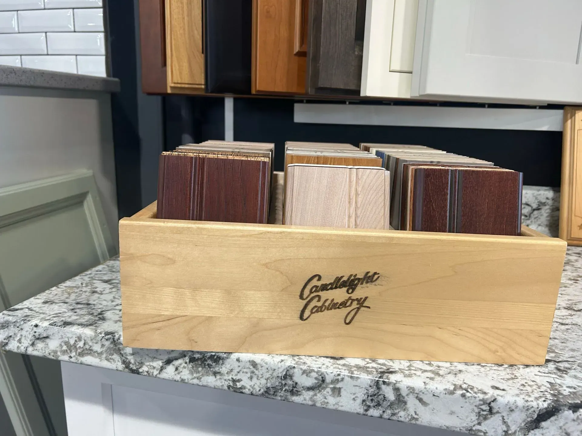 A wooden box filled with wooden samples is sitting on a counter.