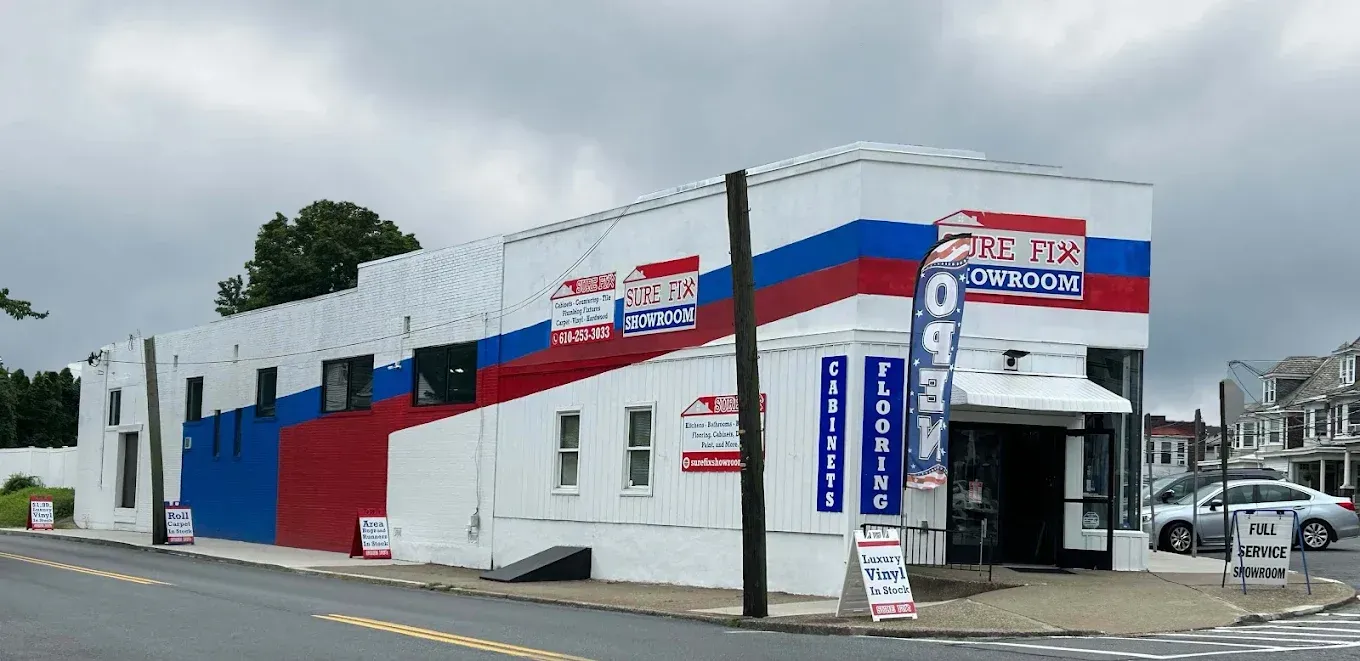 A red , white and blue building is on the corner of a street.