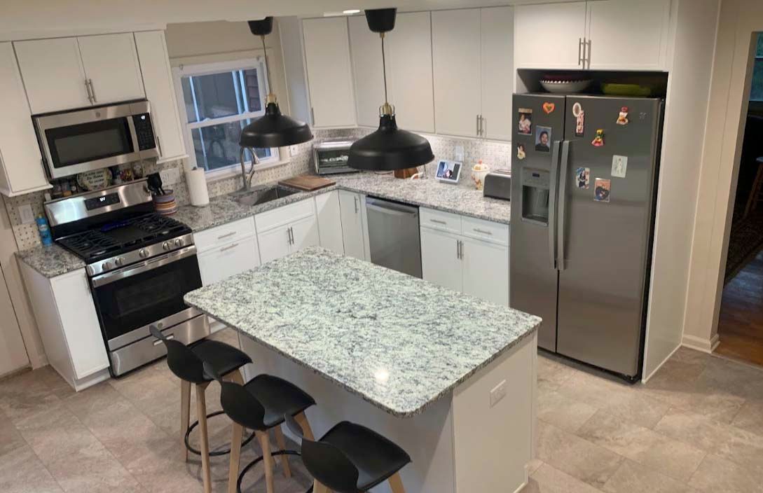 A kitchen with stainless steel appliances and granite counter tops.