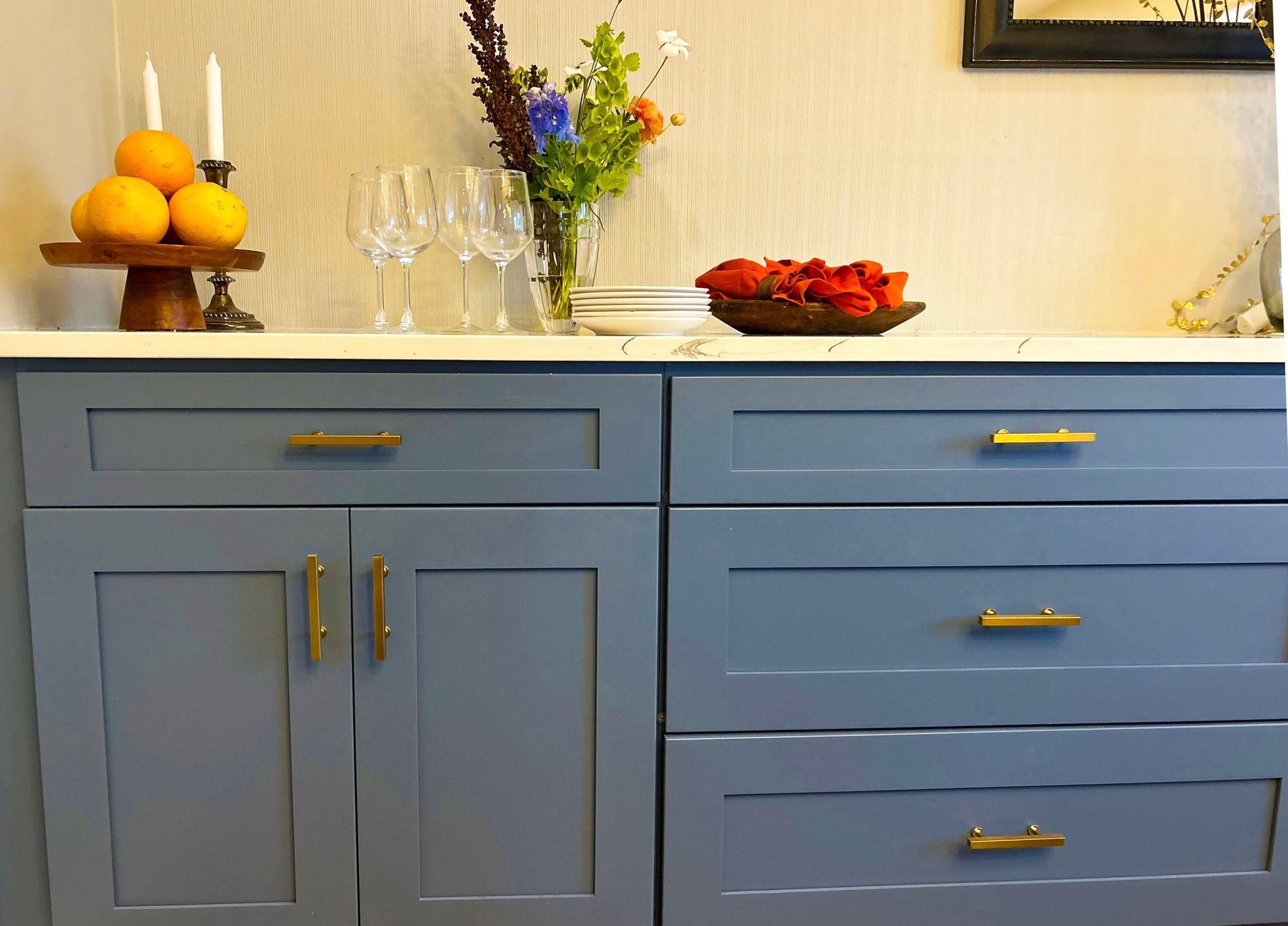A blue cabinet with a vase of flowers on top of it.