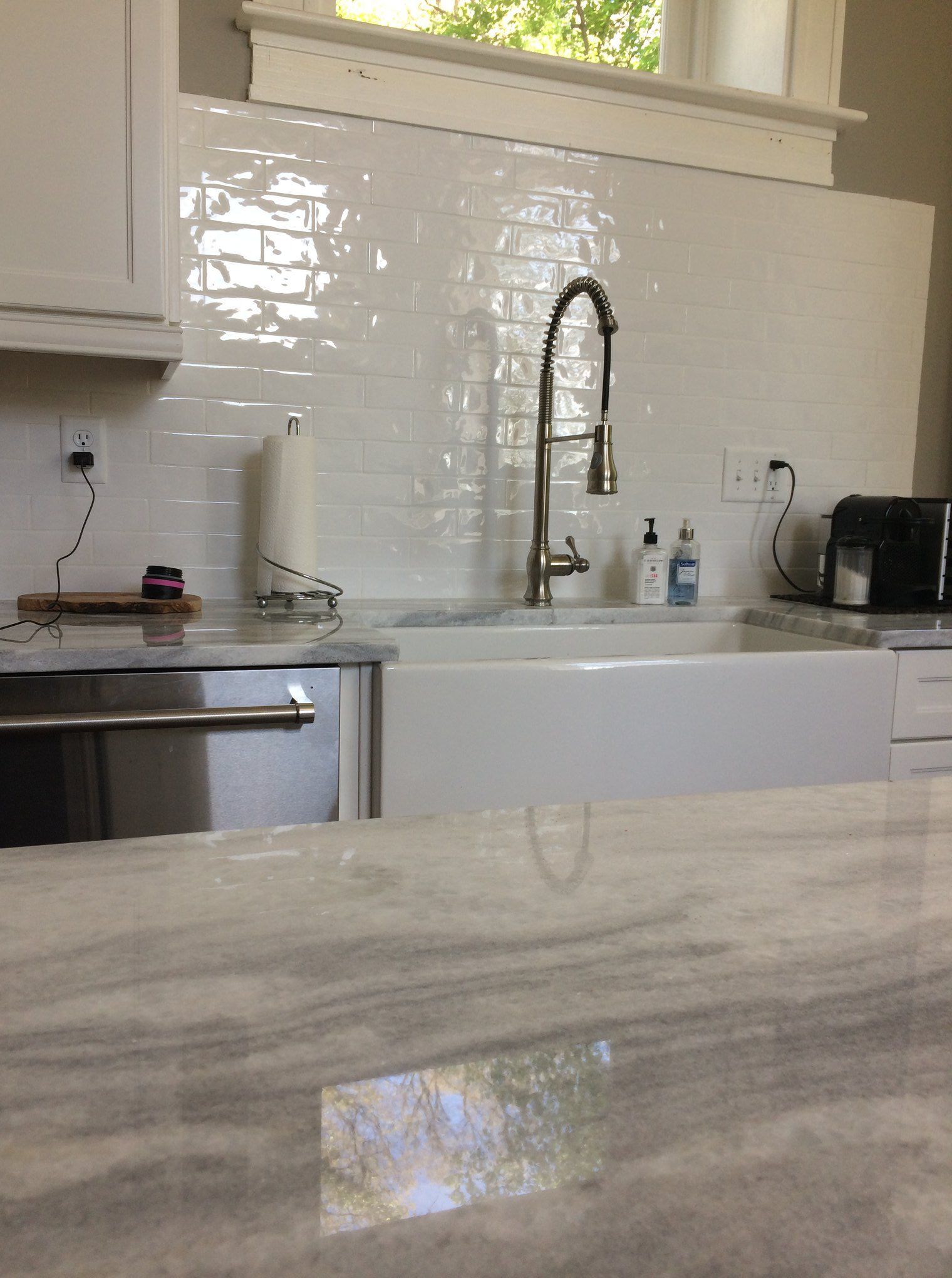 A kitchen with a white sink and a faucet