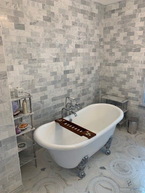 A bathtub with a wooden tray on top of it in a bathroom.