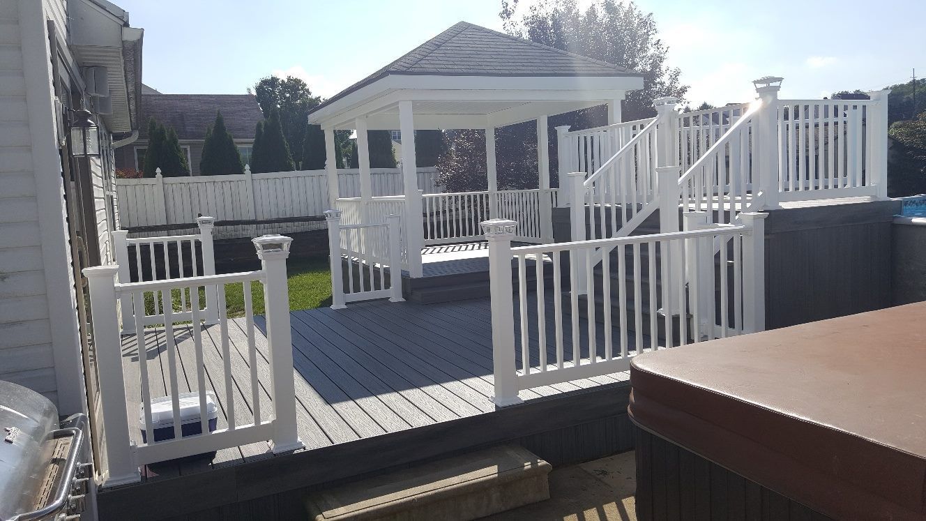 There is a gazebo on the deck with a white railing.