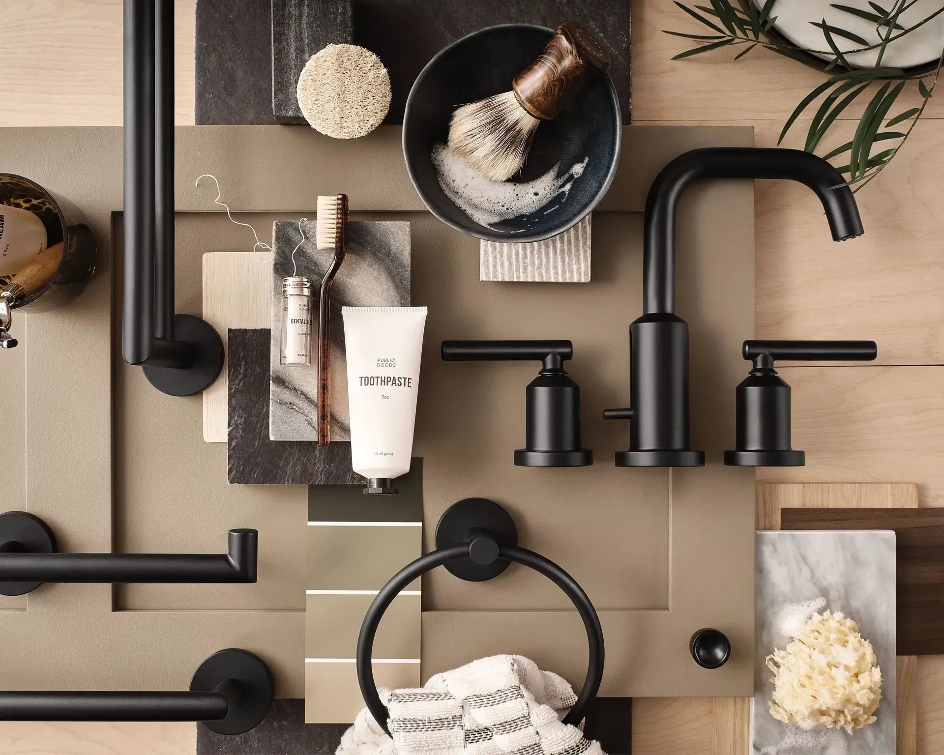 A bathroom with black faucets and shaving brushes