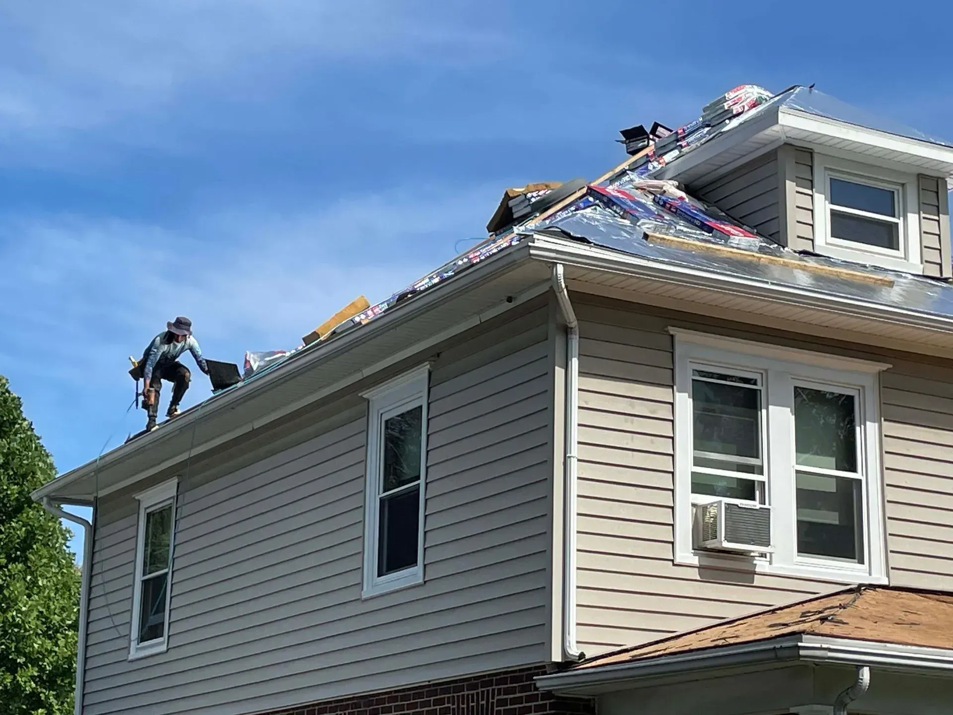 A man is working on the roof of a house.