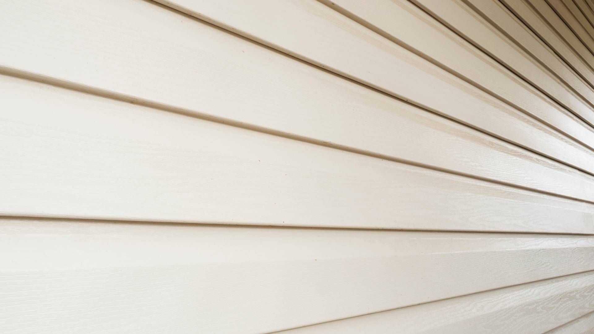 A close up of a white siding on a wall.