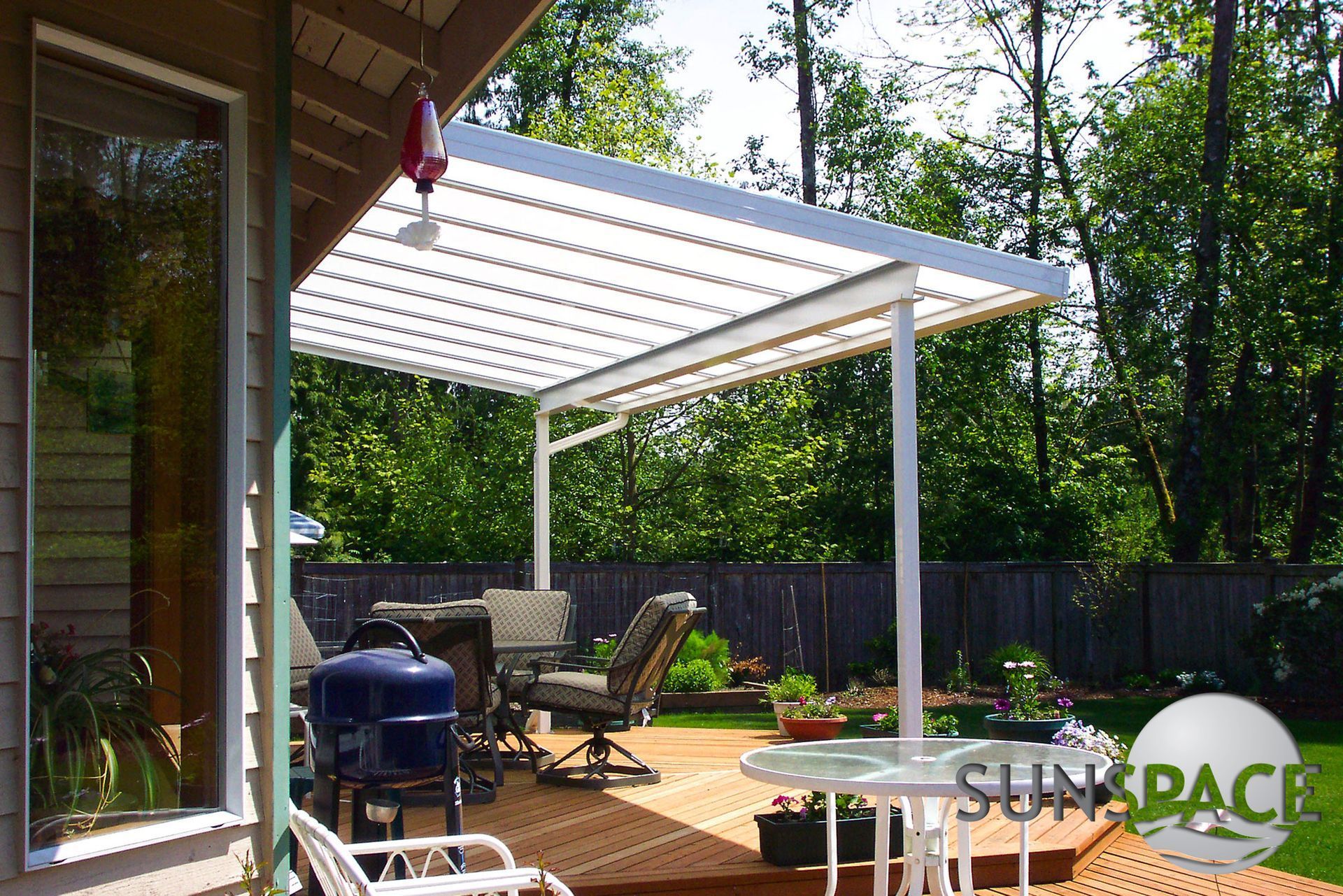 A patio with a table and chairs under a canopy that says sunspace