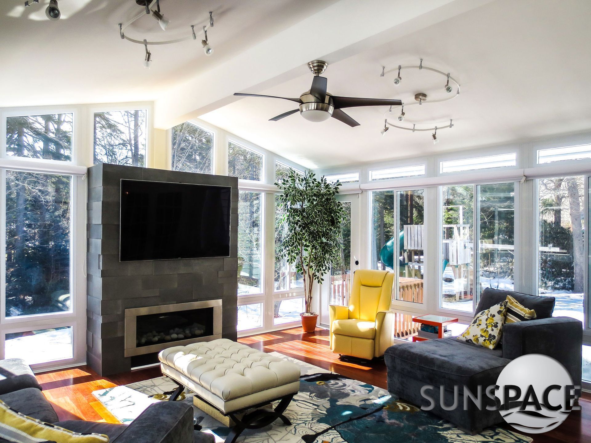 A living room with a ceiling fan and a flat screen tv