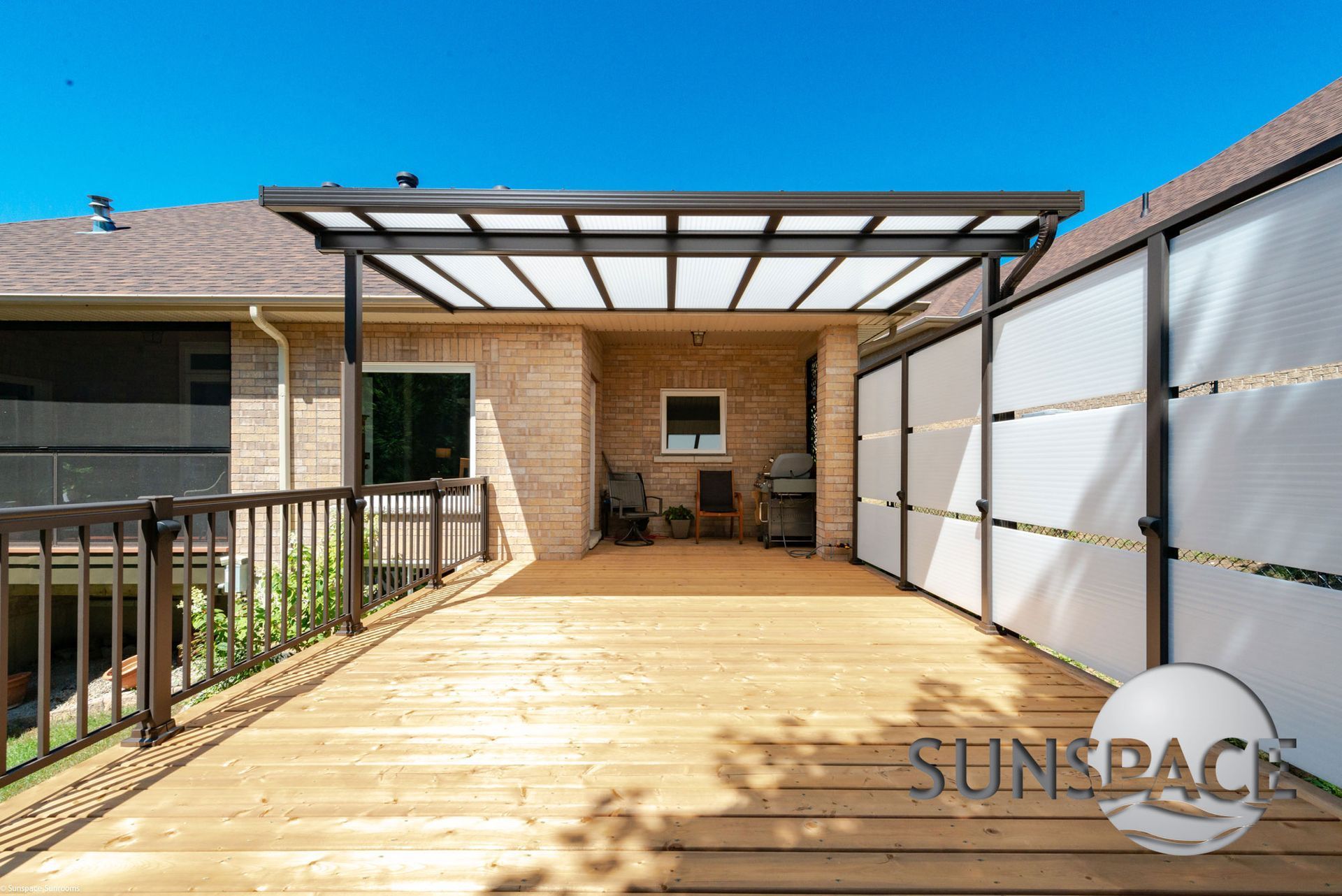 A wooden deck with a pergola and a fence surrounding it.