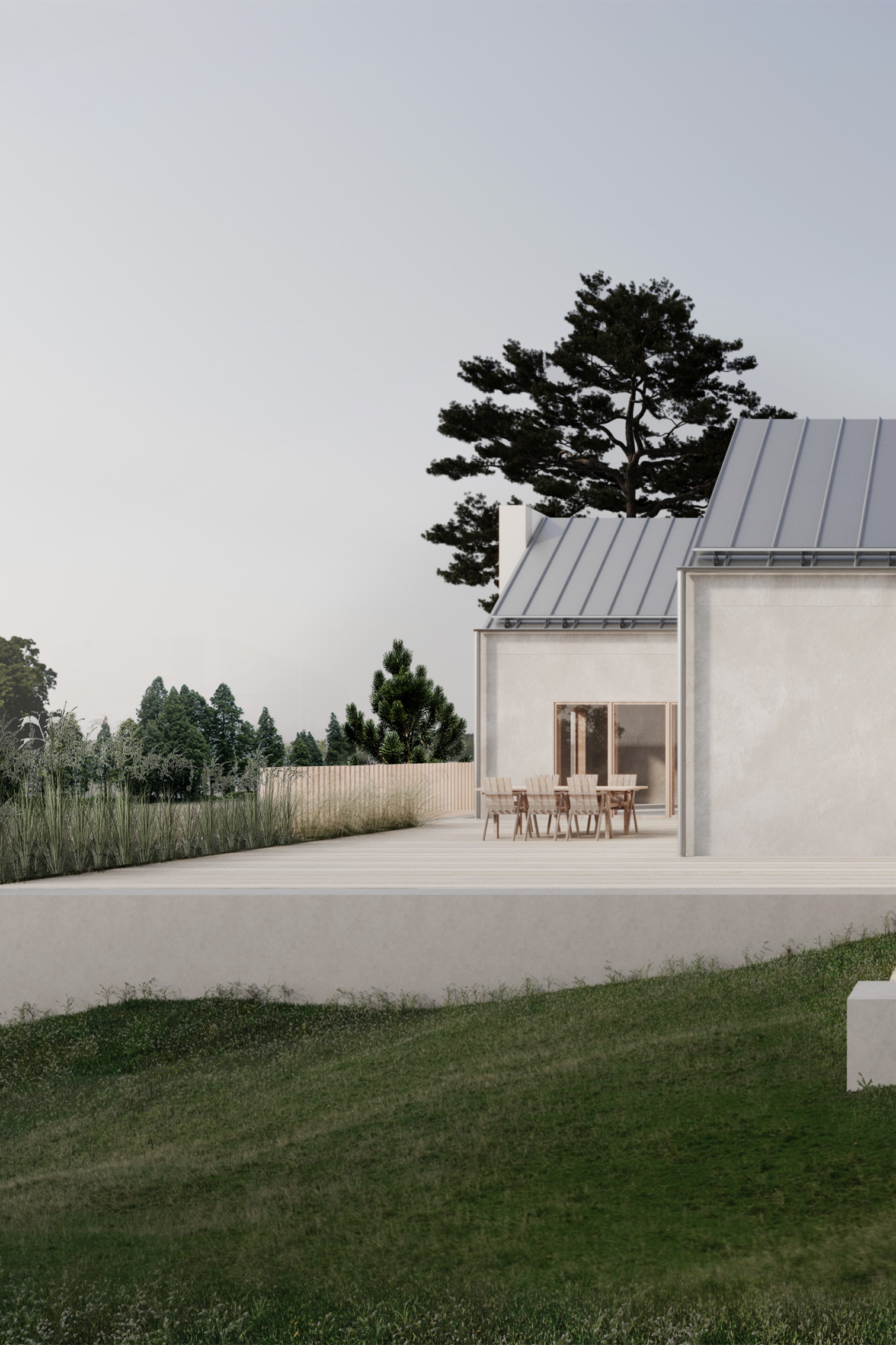 A white house with a metal roof is sitting on top of a lush green field.