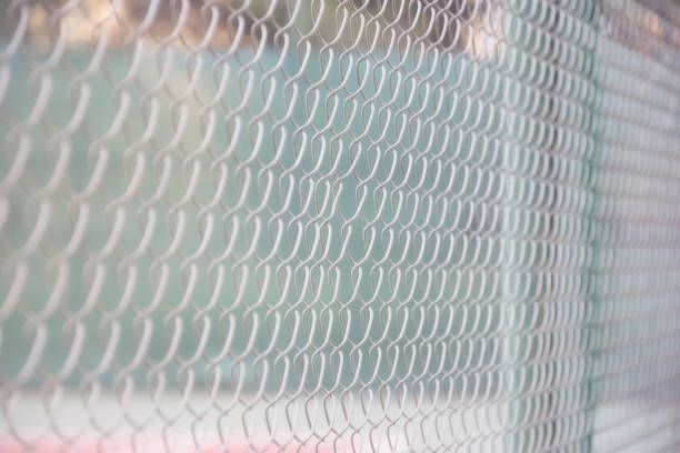 A close up of a chain link fence with a blurred background.