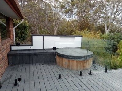 There is a hot tub on the deck of a house.
