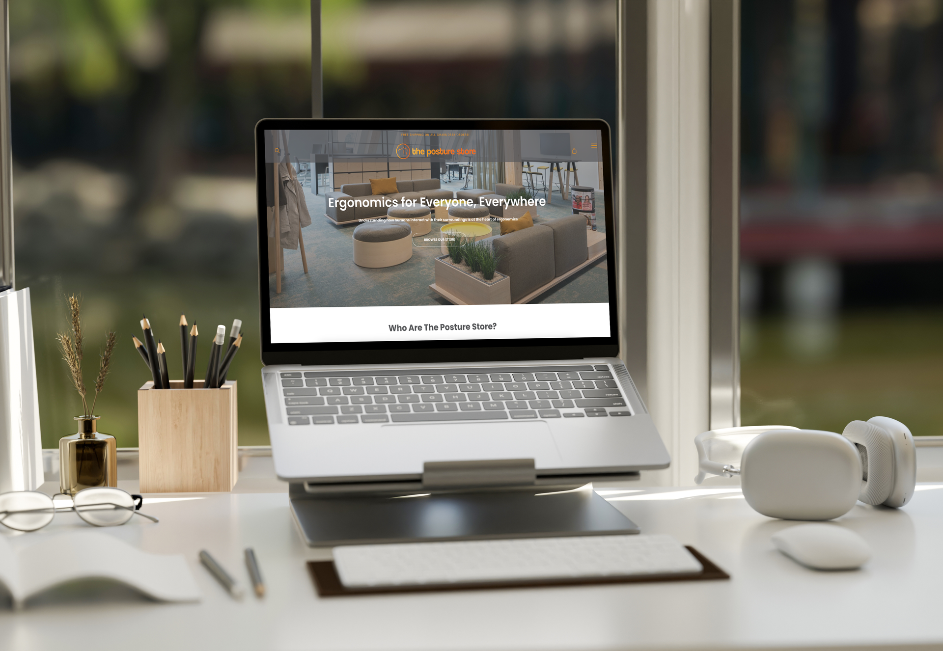 A laptop computer is sitting on a desk next to a window.