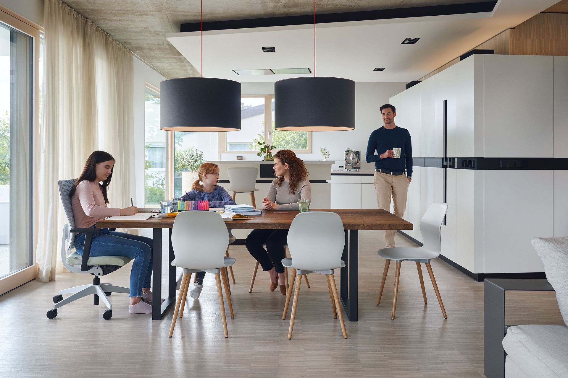 A group of people are sitting at a table in a living room.
