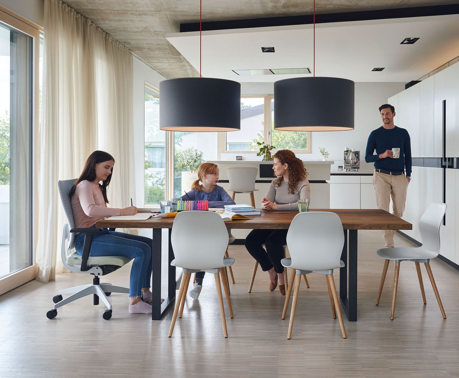 A group of people are sitting at a table in a kitchen.