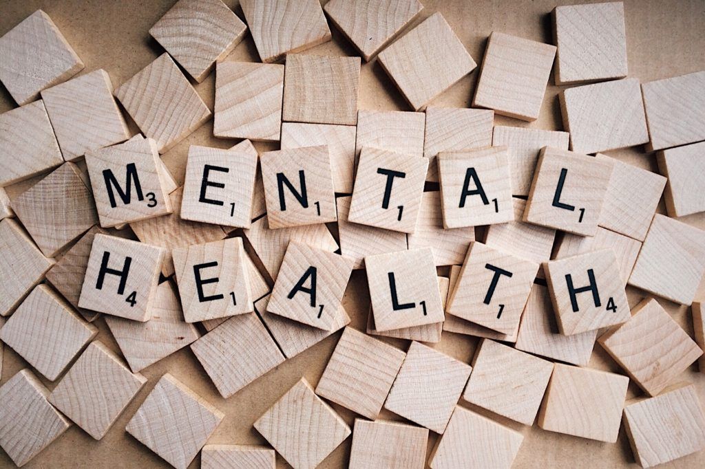 The word mental health is written in scrabble tiles