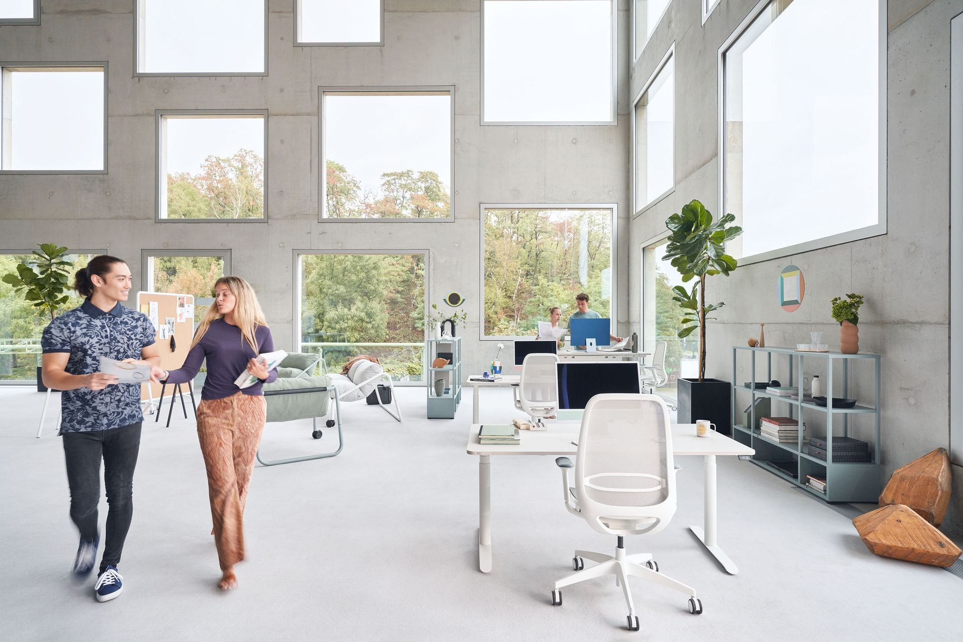 A man and a woman are walking in an office.